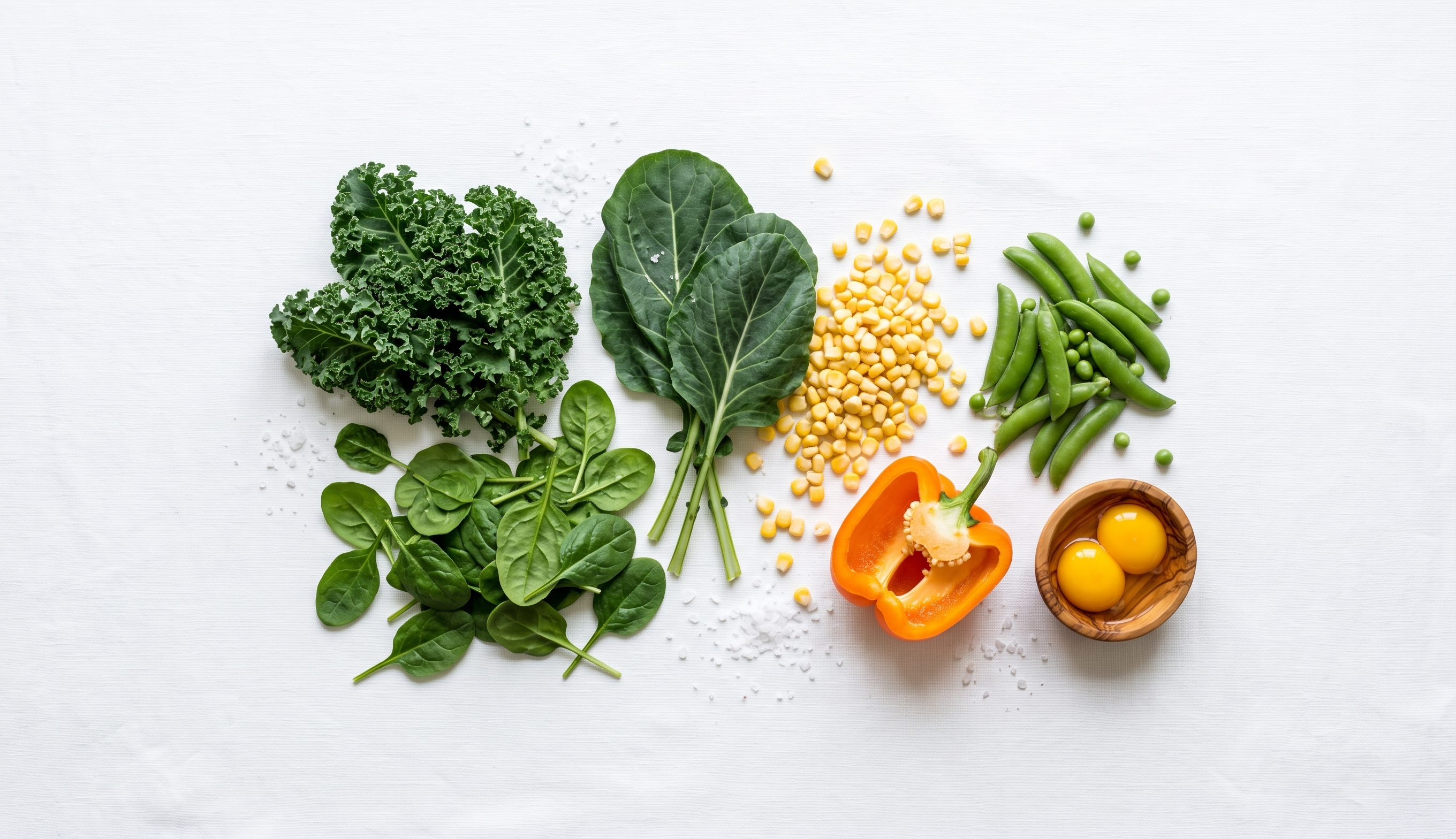 Alimentos ricos en luteína y zeaxantina: espinacas, kale, maíz, yema de huevo y pimiento naranja